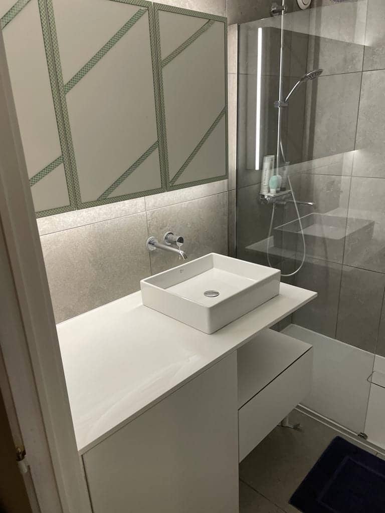 Badkamer met wastafelmeubel en glazen douchewand