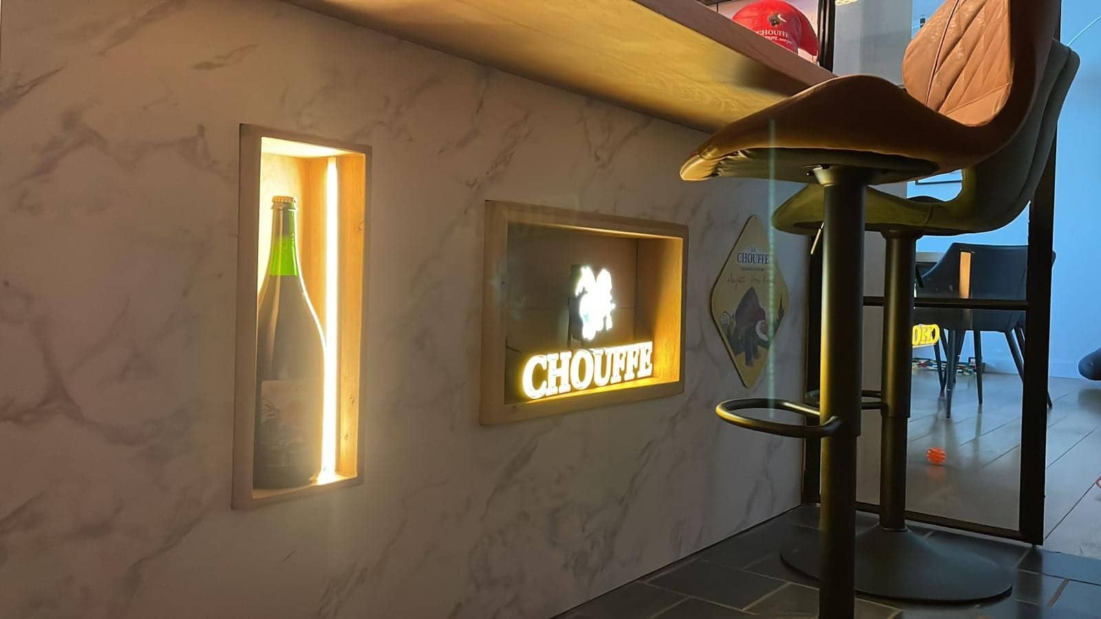 Verlichte nis met fles en lichtreclame in de bar