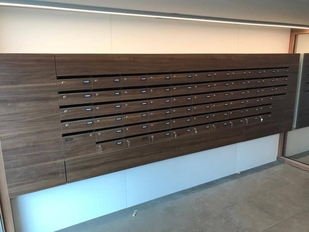 Wand met rijen brievenbussen in donker houtdecor