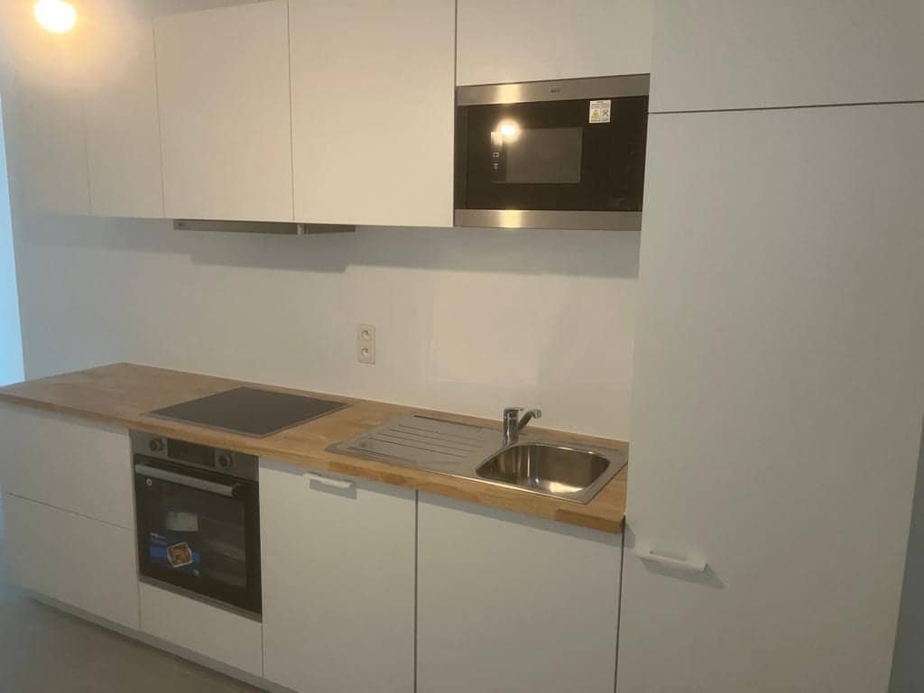 Compacte keuken met hoge kast en microgolfoven in de bovenkasten