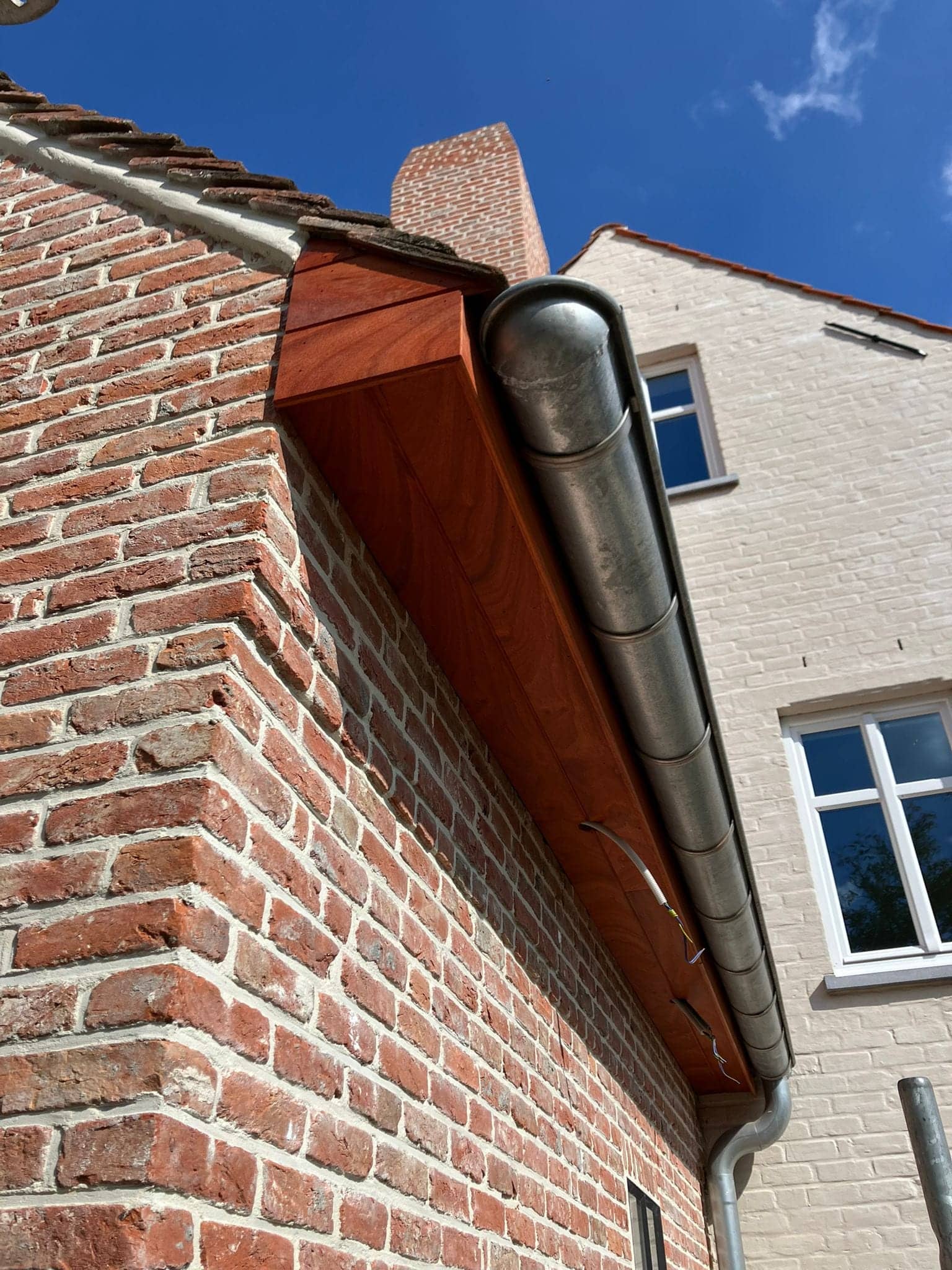 Houten bakgoot en zinken goot aan de hoek van de woning