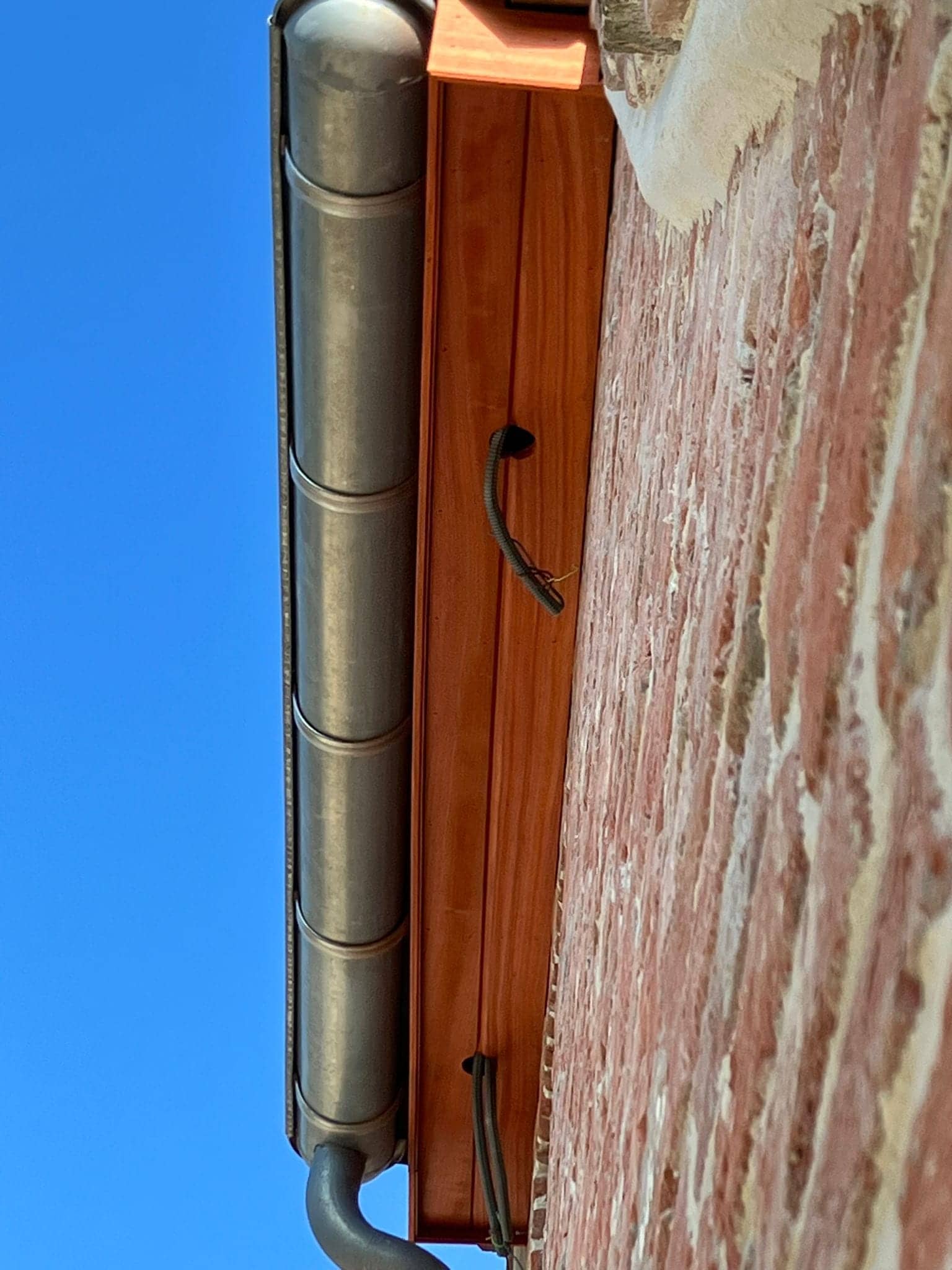 Detail van een houten bakgoot en zinken regenpijp