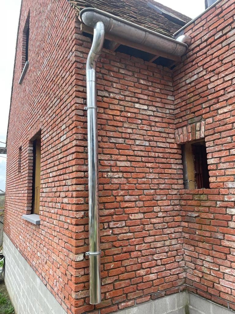 Bakstenen gevel met zinken regenpijp