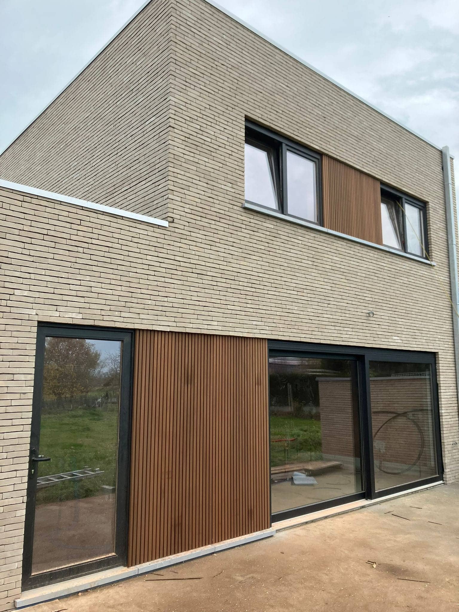 Woning met verticale houten latten tussen de grote ramen