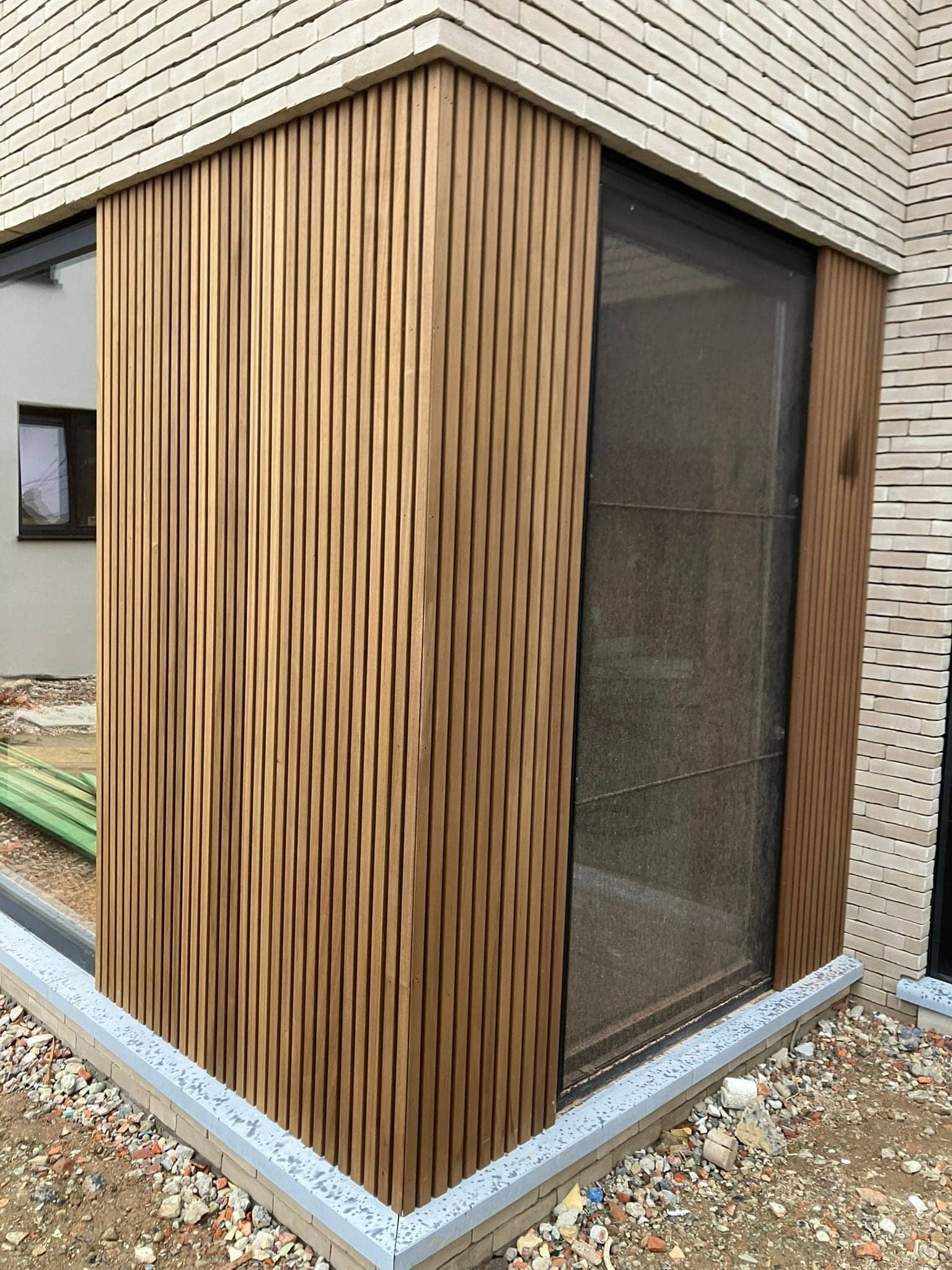 Detail van de verticale thermowood latten naast een hoekraam