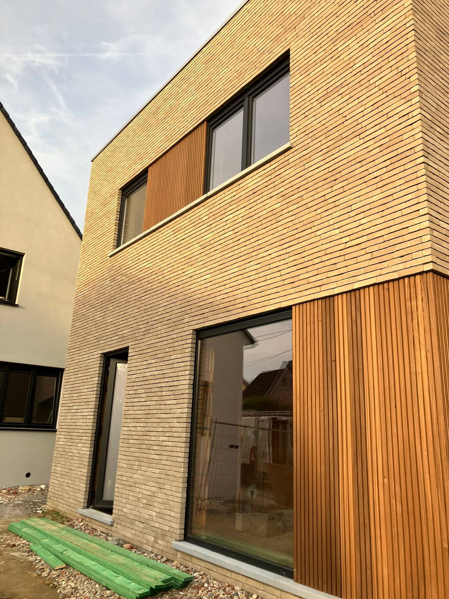Gevel met houten bekleding tussen ramen op twee verdiepingen