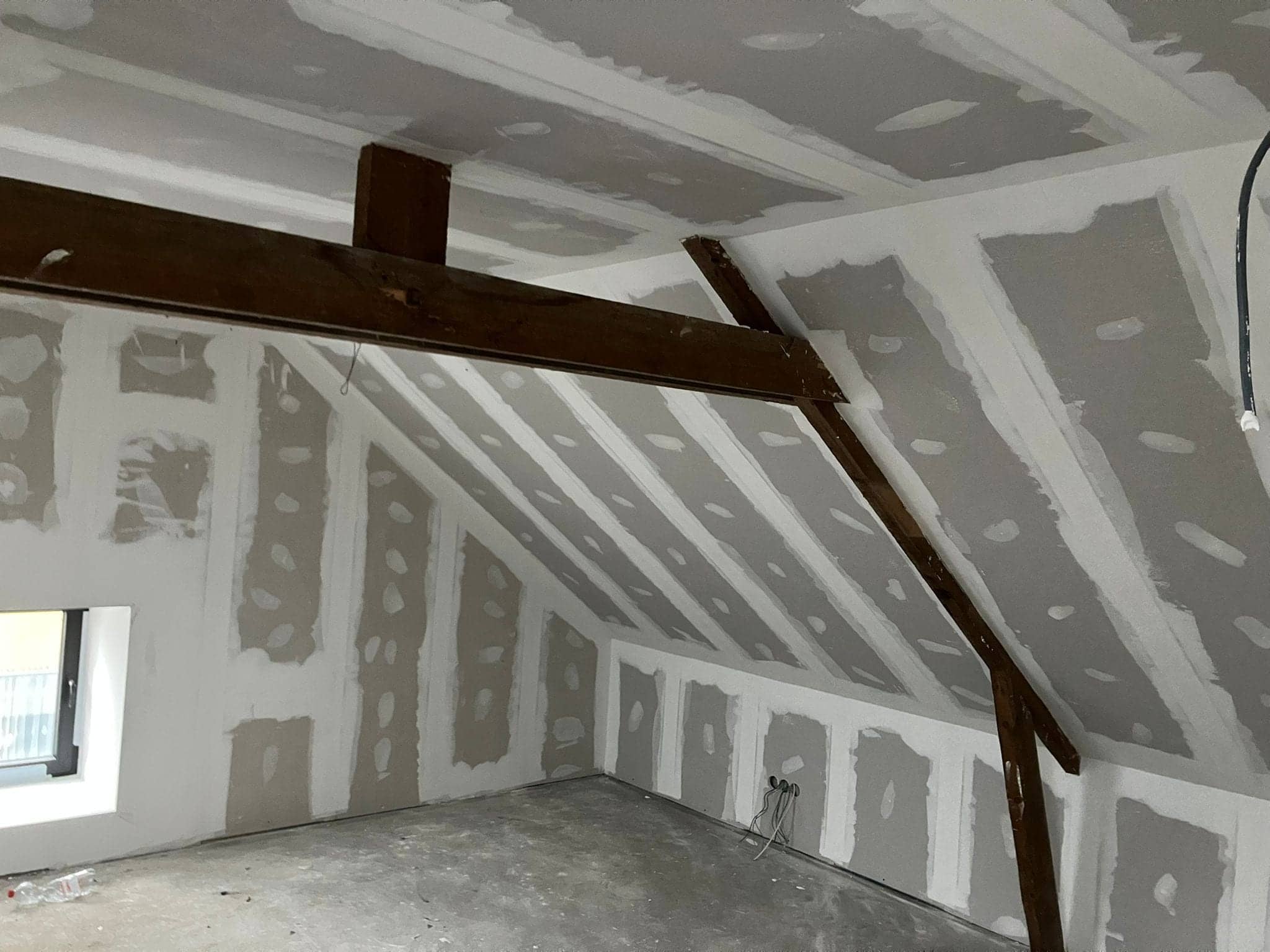 Gyprocwerken op zolder met zichtbare houten spanten