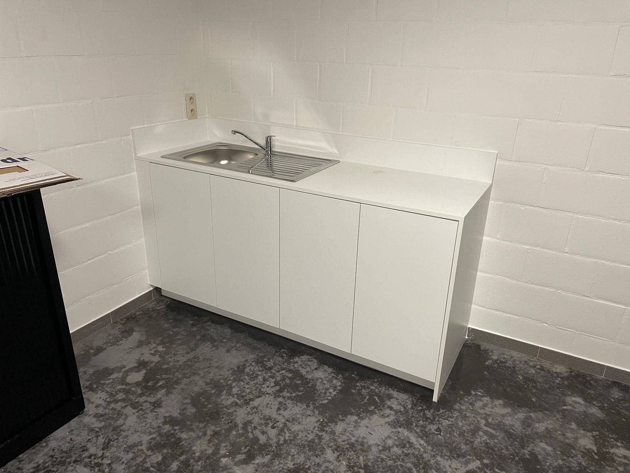 Kleine witte keuken met spoelbak in een bureauruimte