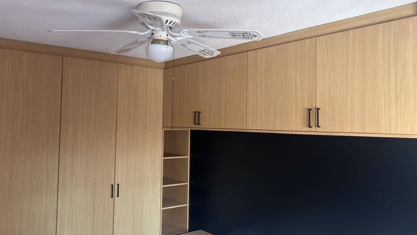 Kastenwand met bovenkasten boven het bed