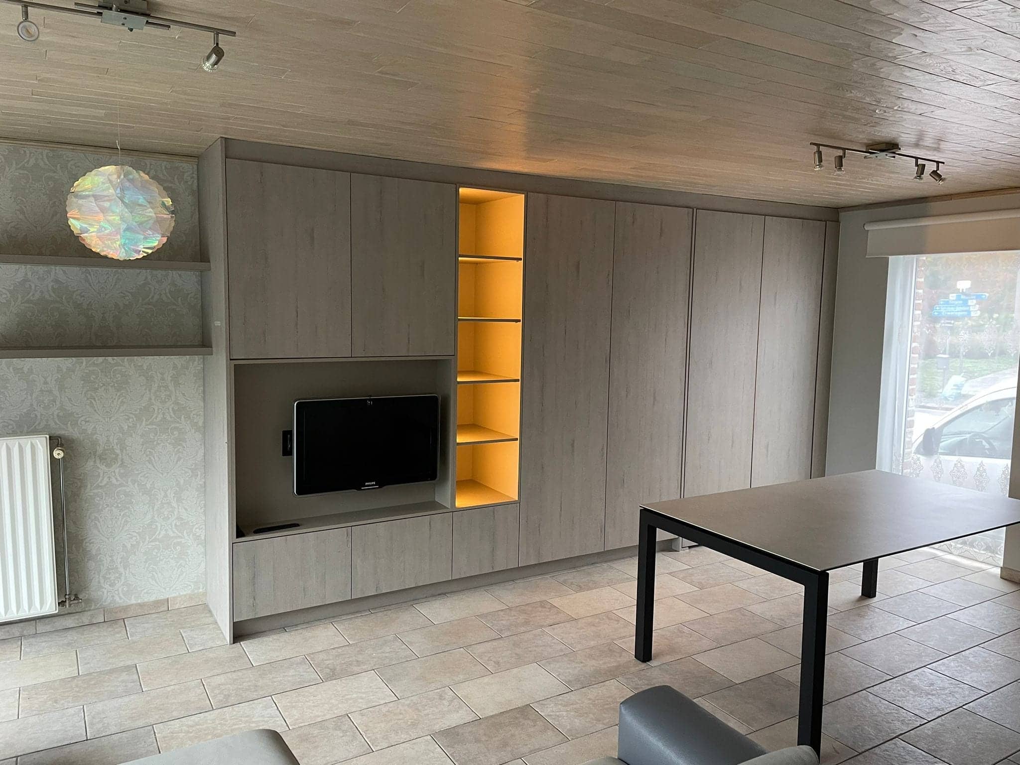 Woonkamerwand met tv-kast, verlichte nis en ingebouwd bureau