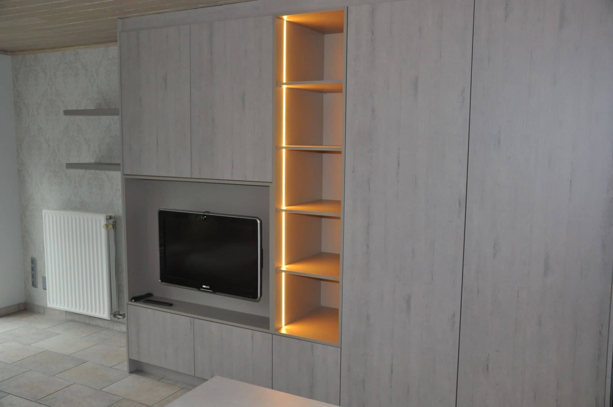 Tv in een nis naast verlichte open legplanken