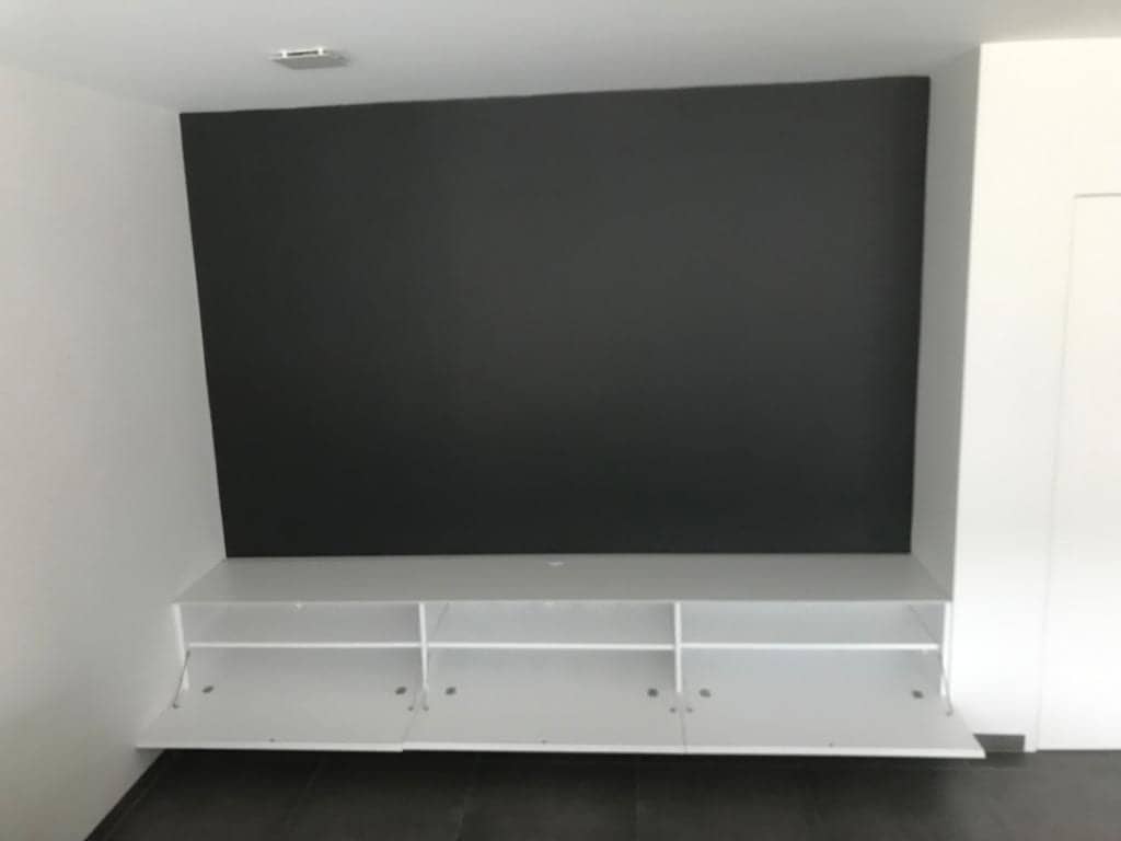 Lang wit tv-meubel onder een donkere wand