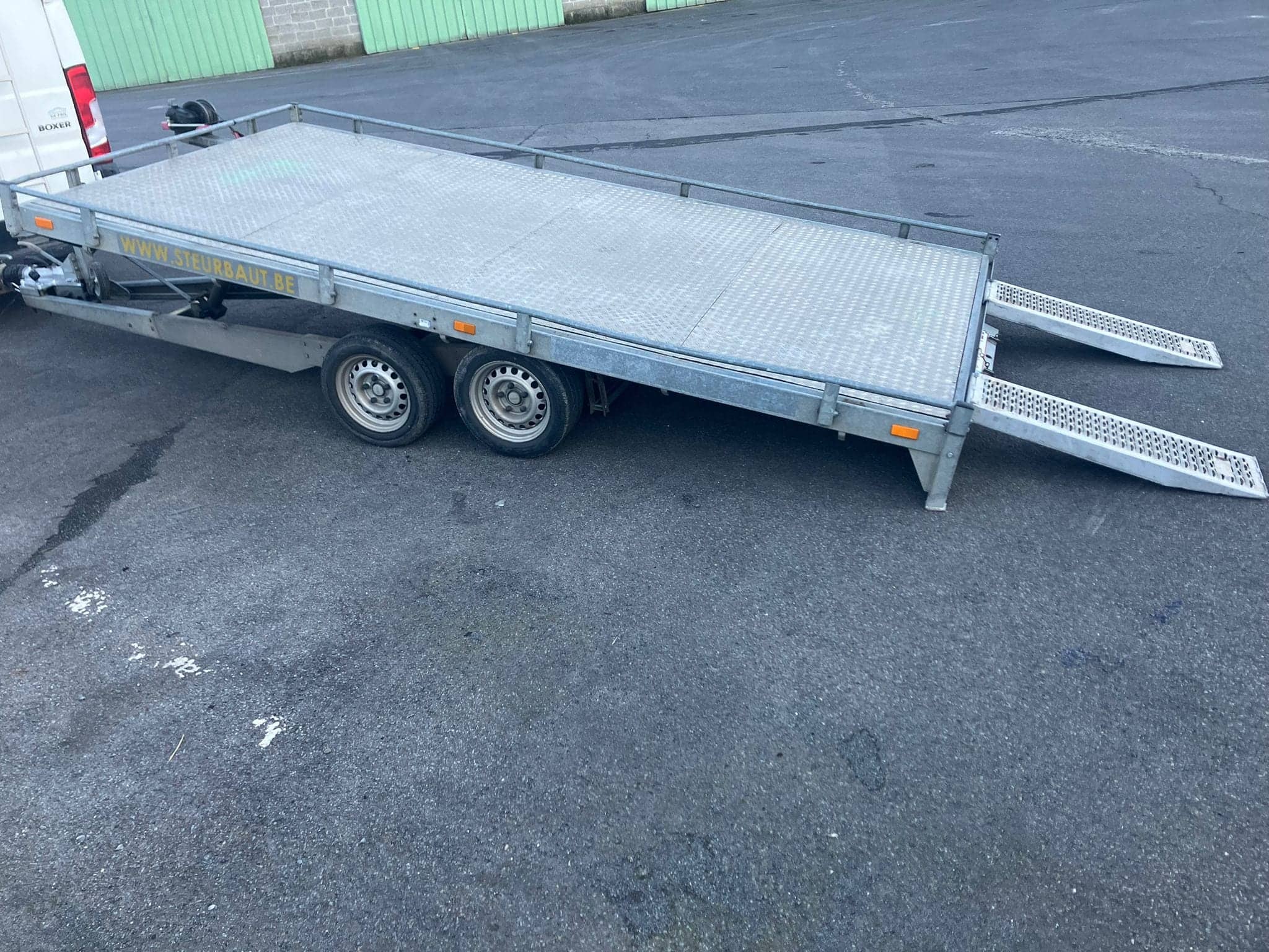 Zijaanzicht van de dubbelasser met oprijplaten