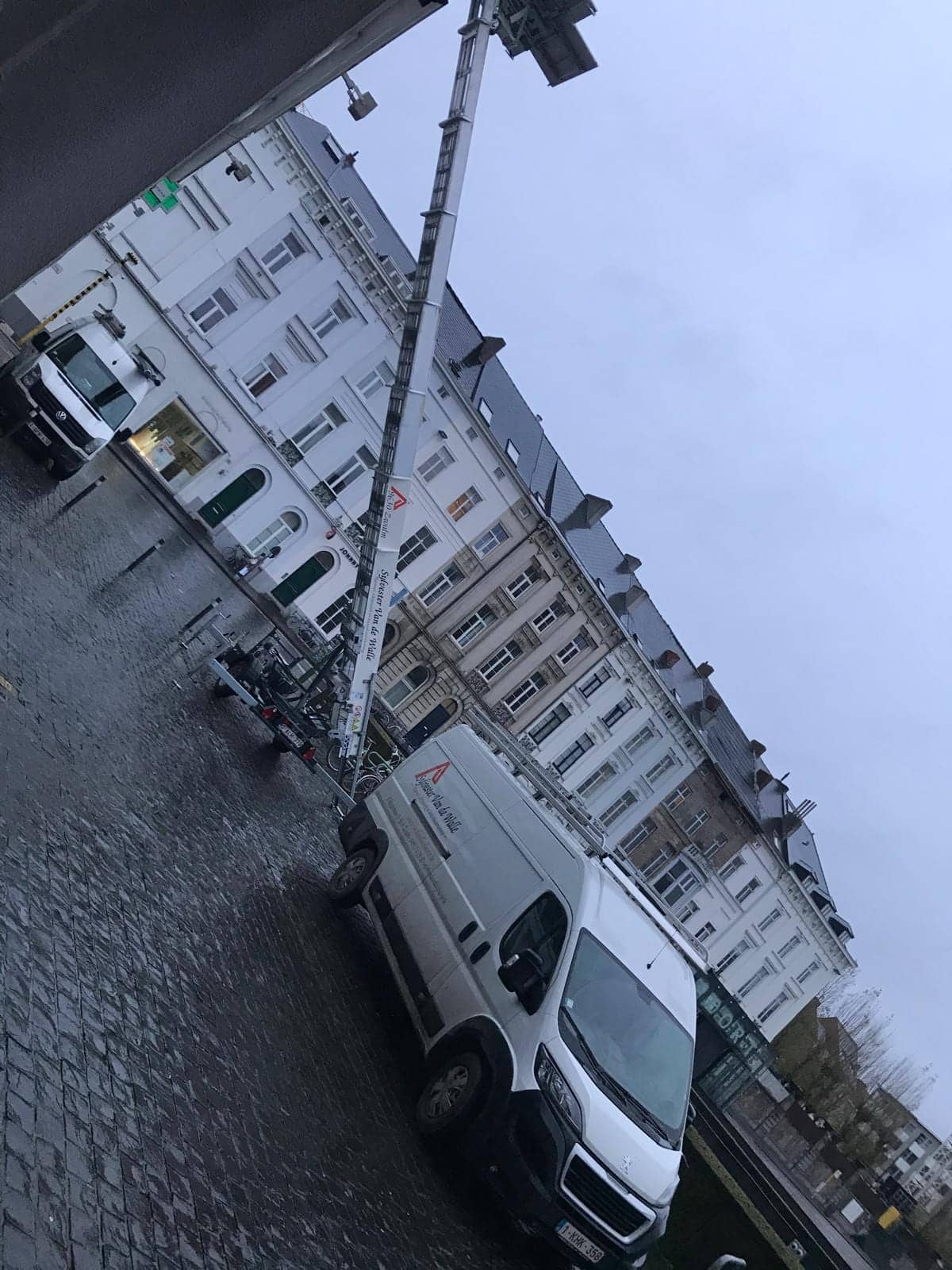 Uitgeschoven verhuislift tegen een appartementsgebouw