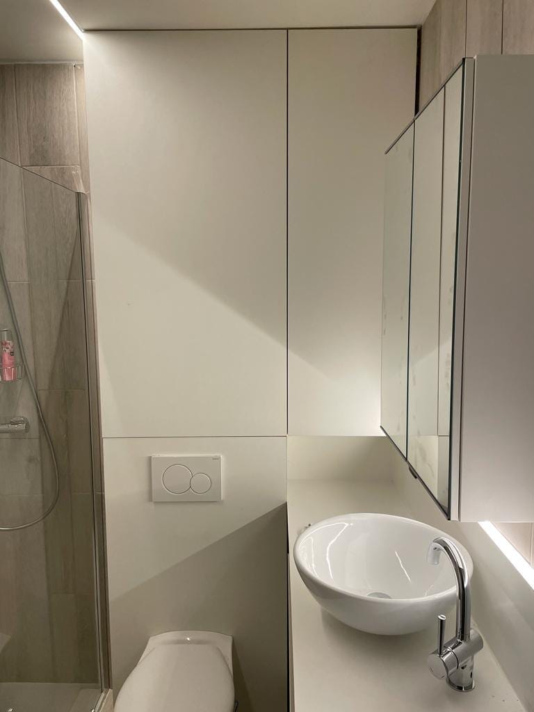 Toiletruimte met hoge witte kasten en waskom