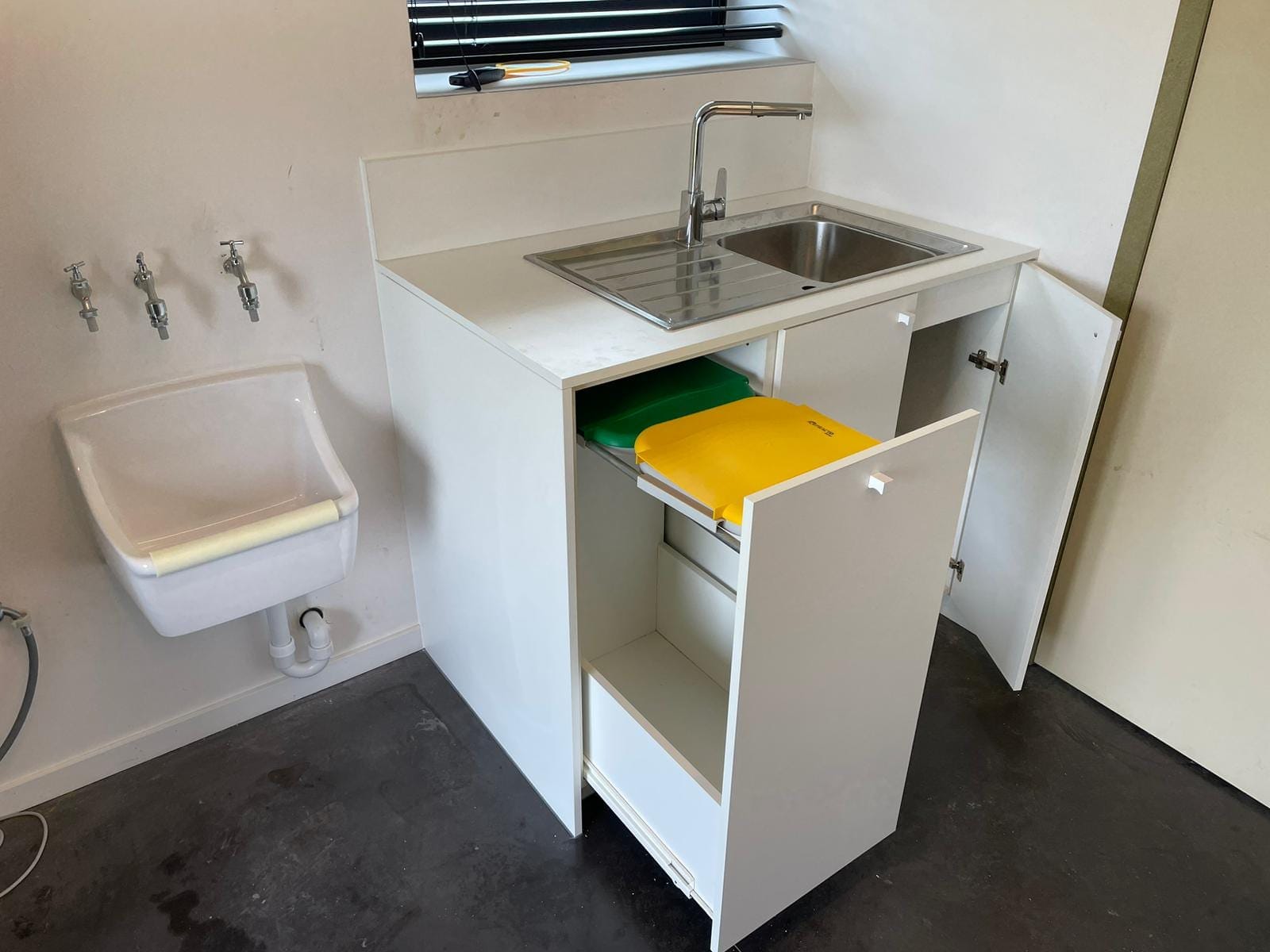 Bergingkast met spoelbak en uitgetrokken afvalbakken