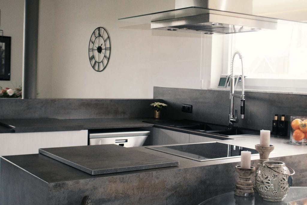 Keuken met kookeiland, dampkap en werkblad in betonlook