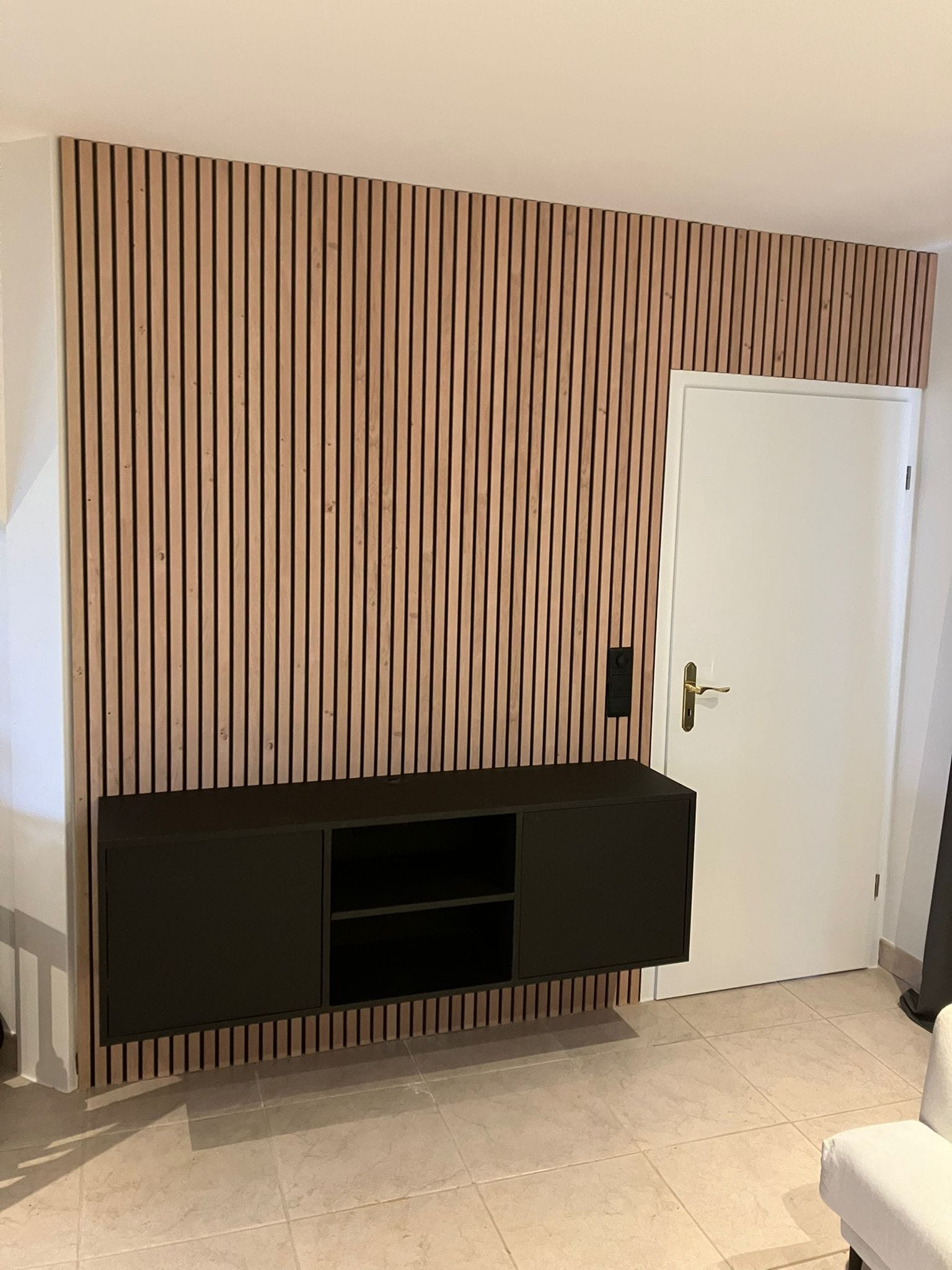 Zwart zwevend tv-meubel voor een wand met verticale houten latten